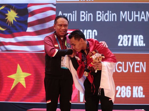 Lifter andalan Indonesia, Eko Yuli Irawan usai menerima pengalungan medali emas Sea Games 2021 dari Menpora Amali