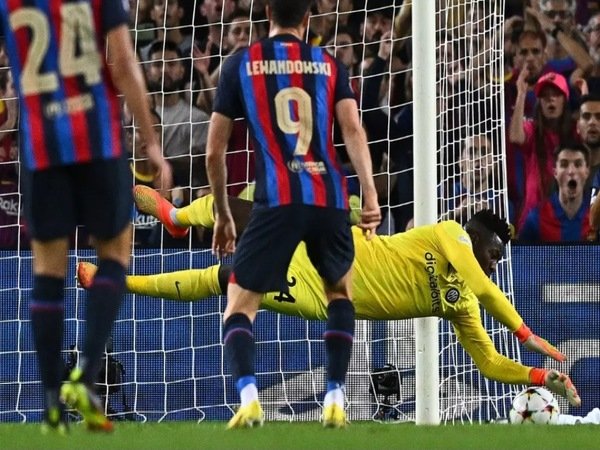 Andre Onana melakukan penyelamatan, saat Inter Milan bermain imbang 3-3 melawan Barcelona di matchday keempat Liga Champions (13/10) / via Getty Images