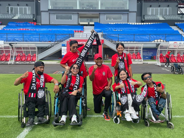 Pemain bertahan Bali United, Leonard Tupamahu bersama suporter disabilitas