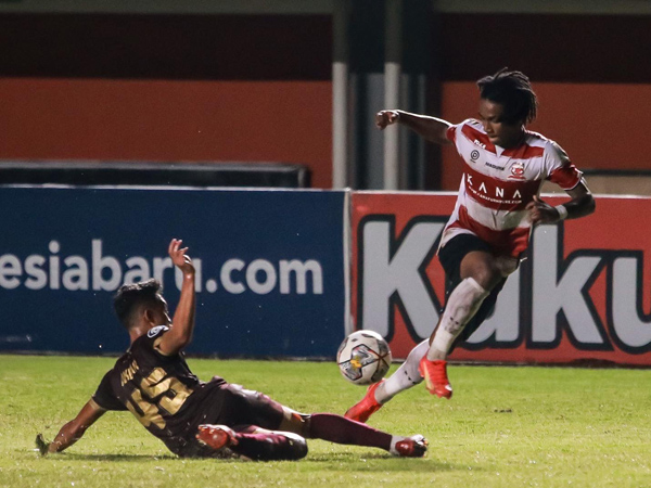 Penyerang Madura United, Ronaldo Kwateh berupaya melewati hadangan pemain PSM Makassar