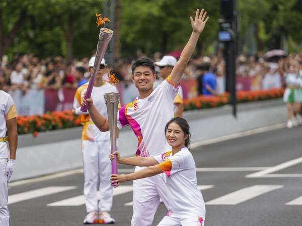 Wu Yibing (kiri) dan Jiang Lijuan berpose pada hari terakhir kirab obor Asian Games ke-19 pada Rabu (20/9/2023) di Hangzhou, Provinsi Zhejiang, China timur. (Foto: Xinhua)