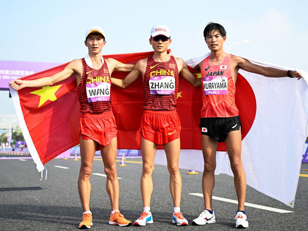 Peraih medali emas Zhang Jun (tengah), peraih medali perak Wang Zhaozhao dari China (kiri) dan peraih medali perunggu Yutaro Murayama dari Jepang berpose setelah lomba jalan cepat 20km putra di Asian Games Hangzhou. (Foto: Xinhua)