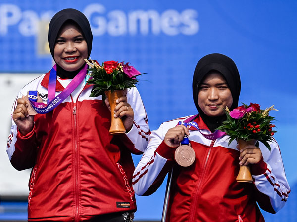 Retno Wahyu Wulandari dan Aulia Mahda berpose dengan medali perunggu mereka di cabor panahan nomor double recurve putri di Asian Para Games Hangzhou. (Foto: Xinhua)