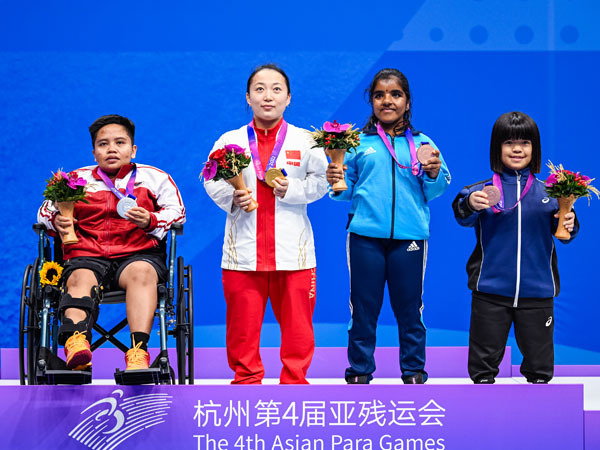 Atlet bulu tangkis Indonesia Rina Marlina (paling kiri) terpaksa duduk di kursi roda di atas podium pengalungan medali setelah mengalami cedera di babak final tunggal putri SH6 melawan wakil tuan rumah Li Fengmei di Asian Para Games Hangzhou. (Foto: Xinhu