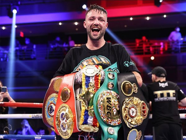 Josh Taylor berpose dengan sabuk-sabuknya saat menjadi juara kelas welter junior sejati. (Foto: Top Rank)