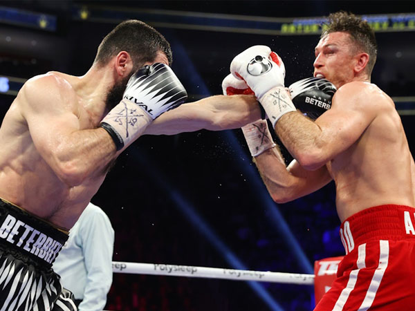 Arthur Beterbiev (kiri) mendaratkan pukulan pada Callum Smith. (Foto: Top Rank)