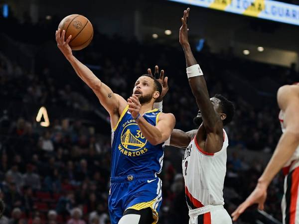 Stephen Curry (kiri) mencetak 22 poin saat Golden State Warriors menang 100-92 atas Portland Trail Blazers pada Kamis (11/4) malam. (Foto: AP)
