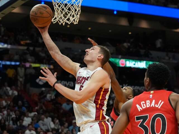 Nikola Jovic (kiri) mencetak 22 poin saat Miami Heat mengalahkan Toronto Raptors 125-103 pada Jumat (12/4) malam. (Foto: AP)