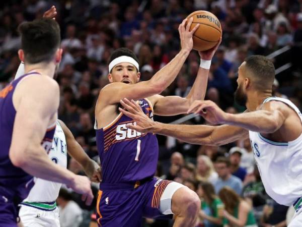 Devin Booker (tengah) mencetak 23 poin saat Phoenix Suns mengalahkan Minnesota Timberwolves 125-106 pada hari Minggu (14/4). (Foto: AP)