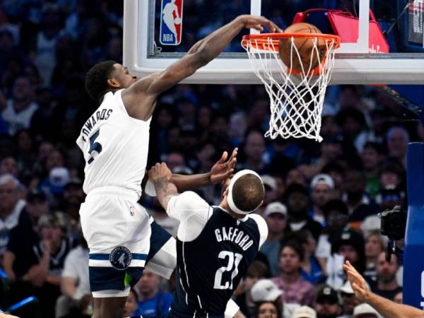 Anthony Edwards melakukan dunk terhadap center Mavs Daniel Gafford di Game 3 pada Minggu (26/5).(Foto: Reuters)