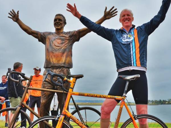Bill Walton berdiri di samping patung perunggu dirinya dan sepedanya di Ski Beach Park di San Diego. (Foto: San Diego News).