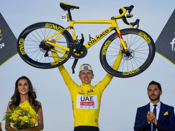 Tadej Pogacar merayakan suksesnya memenangi Tour de France ketiganya di atas podium. (Foto: AFP)
