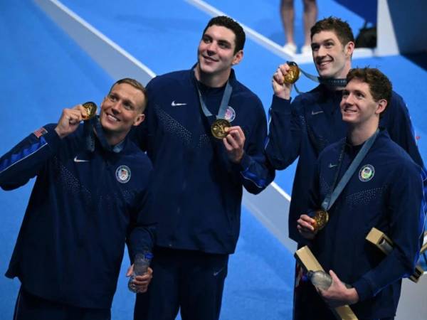 Caeleb Dressel (paling kiri) dan ketiga rekannya merayakan emas 4x100 gaya bebas estafet putra yang mereka rebut di Olimpiade Paris pada Sabtu (27/7). (Foto: AP)