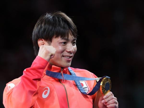 Pejudo veteran Jepang, Hifumi Abe, memamerkan medali emasnya setelah berhasil mempertahankan gelar juara Olimpiade di kelas 66kg putra pada Minggu (28/7). (Foto: The Japan News)