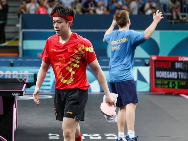 Wang Chuqin (kiri) meninggalkan lapangan setelah pertandingan babak 32 besar melawan Truls Moregard di Olimpiade Paris 2024 pada 31 Juli 2024. (Foto: Xinhua)