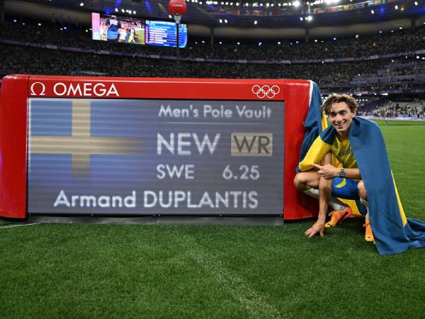 Armand Duplantis berpose dengan papan skor yang menunjukkan dirinya mencetak rekor dunia baru saat mempertahankan gelar lompat galah putra di Olimpiade 2024. (Foto: Xinhua)