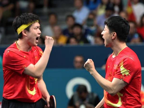 Ma Long (kanan) dan Wang Chuqin dari Chian bereaksi saat bertanding di semifinal beregu putra tenis meja melawan Prancis di Olimpiade Paris pada Kamis (8/8). (Foto: Xinhua)