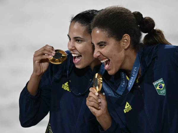 Pasangan Brasil, Ana Patricia dan Duda, melakukan selebrasi setelah memenangi bola voli pantai putri di Olimpiade Paris pada Jumat (9/8). (Foto: Reuters)