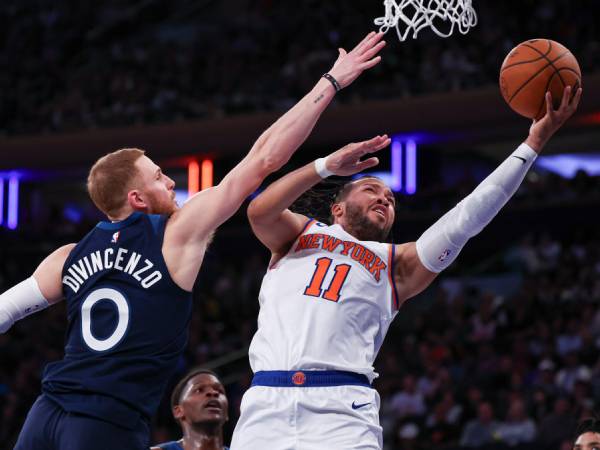 Donte DiVincenzo (kiri) berusaha memblok tembakan Jalen Brunson dalam laga pramusim Wolves-Knicks pada Minggu (13/10). (Foto: AP)
