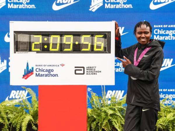 Ruth Chepngetich berpose dengan papan pencatat waktu setelah mencatat rekor dunia di marathon Chicago. (Foto: Reuters)