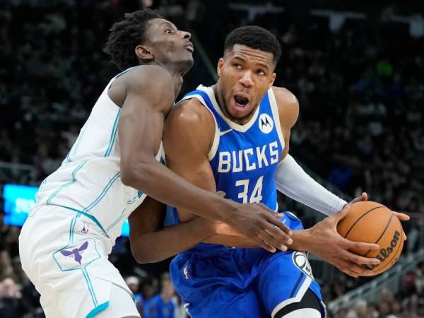 Giannis Antetokounmpo (kanan) membukukan 32 poin saat Milwaukee Bucks mengalahkan tim tamu Charlotte Hornets 125-119 pada Sabtu (23/11) malam. (Foto: AP)