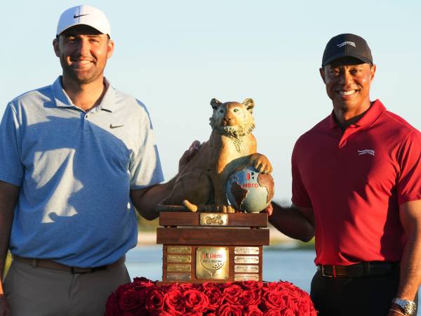 Scottie Scheffler (kiri) berpose dengan trofi Hero World Challenge bersama Toger Woods. (Foto: Golf Digest)