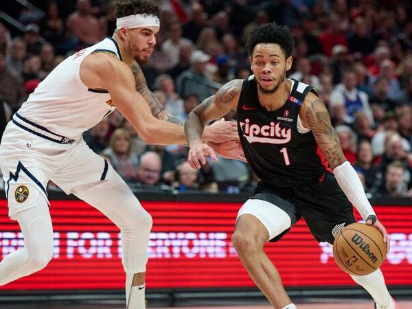 Anfernee Simons (kiri) mencetak 28 poin saat Portland Trail Blazers menang 126-124 atas tim tamu Denver Nuggets pada Kamis (19/12) malam. (Foto: AP)