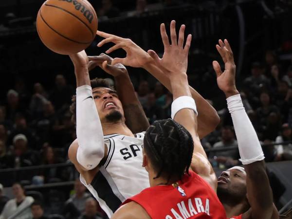 Victor Wembanyama (kiri) mencetak 30 poin saat San Antonio Spurs meraih kemenangan 114-94 atas Portland Trail Blazers pada hari Sabtu (21/12) malam. (Foto: AP)