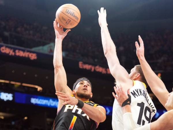 Devin Booker (kiri) mencetak 47 poin saat Phoenix Suns menang 135-127 atas tim tamu Utah Jazz melalui babak perpanjangan waktu pada Jumat (7/2) malam. (Foto: AP)