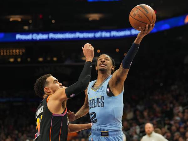 Ja Morant (kanan) mencetak 26 poin saat Memphis Grizzlies membukukan kemenangan 119-112 atas tuan rumah Phoenix Suns pada Selasa (11/2) malam. (Foto: AP)