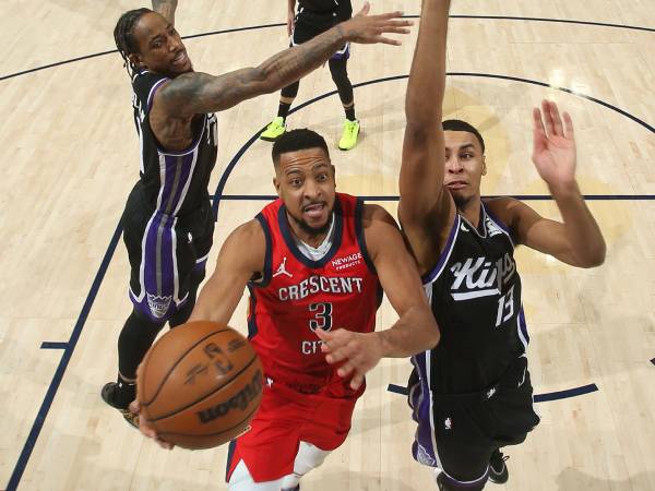 CJ McCollum (kiri) mencetak 43 poin saat tuan rumah New Orleans Pelicans mengalahkan Sacramento Kings 140-133 pada Kamis (13/2) malam. (Foto: AP)
