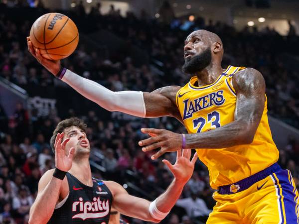 LeBron James (kanan) mencetak 40 poin saat Los Angeles Lakers meraih kemenangan 110-102 atas tuan rumah Portland Trail Blazers pada Kamis (21/2) malam. (Foto: AP)