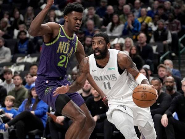 Kyrie Irving (kiri) mencetak 35 poin saat tuan rumah Dallas Mavericks meraih kemenangan 111-103 atas New Orleans Pelicans pada Jumat (21/2) malam. (Foto: AP)
