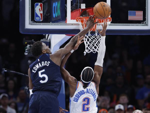 Anthony Edwards (kiri) melakukan blok pada detik-detik akhir babak perpanjangan waktu saat Minnesota Timberwolves menang 131-128 atas Oklahoma City Thunder pada hari Senin (24/2) malam. (Foto: AP)