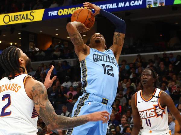Ja Morant (tengah) mencetak 29 poin saat tuan rumah Memphis Grizzlies mengalahkan Phoenix Suns 151-148 pada Selasa (25/2) malam. (Foto: AP)
