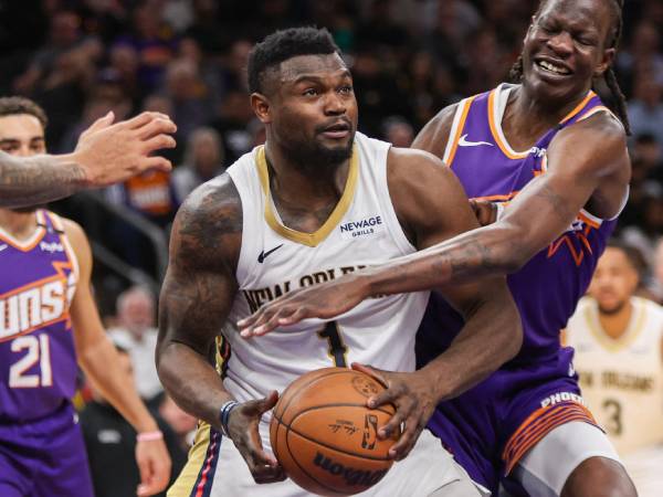 Zion Williamson (kiri) mencetak triple-double saat New Orleans Pelicans meraih kemenangan 124-116 atas Phoenix Suns pada Kamis (27/2) malam. (Foto: AP)