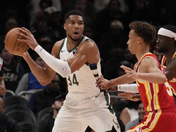 Giannis Antetokounmpo (kiri) membukukan triple-double saat tim tamu Milwaukee Bucks meraih kemenangan 127-121 atas Atlanta Hawks pada Selasa (4/3) malam. (Foto: AP)