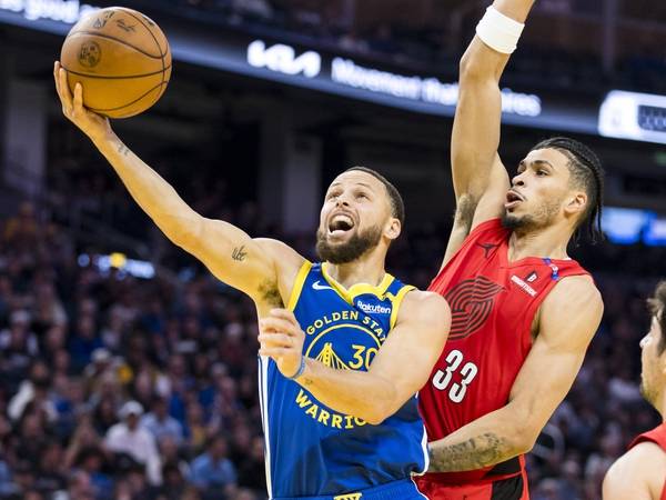Stephen Curry (kiri) mencetak 24 poin saat Golden State Warriors mengalahkan Portland Trail Blazers 130-120 di San Fransisco pada Senin (10/3) malam. (Foto: AP)