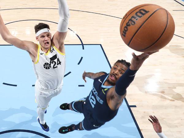 Ja Morant (kanan) mencetak 28 poin saat Memphis Grizzlies mengalahkan tim tamu Utah Jazz 122-115 pada Rabu (12/3) malam. (Foto: AP)
