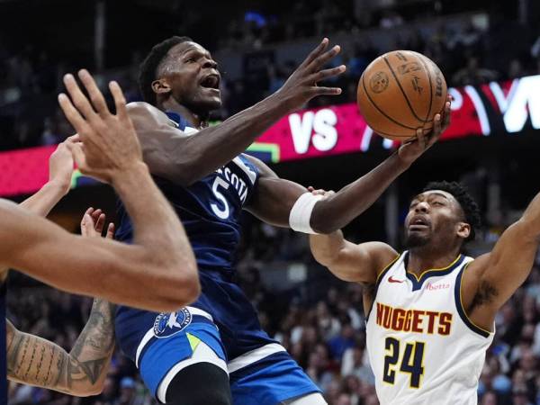 Anthony Edwards (kiri) mencetak 29 poin saat tim tamu Minnesota Timberwolves mengalahkan Denver Nuggets 115-95 pada hari Rabu (12/3) malam. (Foto: AP)