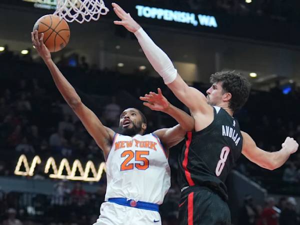 Mikal Bridges (kiri) mencetak 33 poin termasuk lemparan tiga angka penentu kemenangan saat New York Knicks menang 114-113 atas tuan rumah Portland Trail Blazers melalui babak overtime pada Rabu (12/3) malam. (Foto: AP)