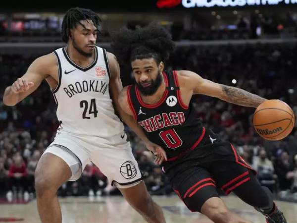 Coby White (kanan) mencetak 31 poin saat Chicago Bulls mengalahkan tim tamu Brooklyn Nets 116-110 pada Kamis (13/3) malam. (Foto: AP)