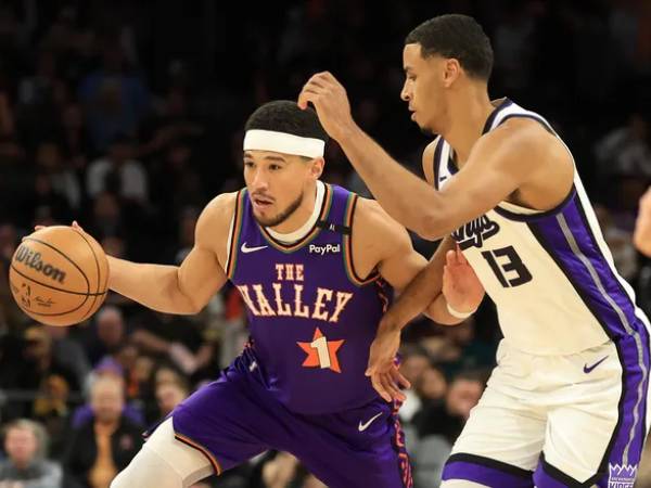Devin Booker (kiri) mencetak 22 poin saat Phoenix Suns meraih kemenangan telak 122-106 atas tim tamu Sacramento Kings pada Jumat (14/3) malam. (Foto: AP)
