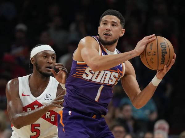 Devin Booker (kanan) mencetak 27 poin saat Phoenix Suns menang 129-89 atas Toronto Raptors pada Senin (17/3) malam. (Foto: AP)