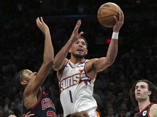 Devin Booker (kanan) mencetak 41 poin saat Phoenix Suns mengalahkan tim tamu Chicago Bulls 127-121 pada hari Rabu (19/3) malam. (Foto: AP)