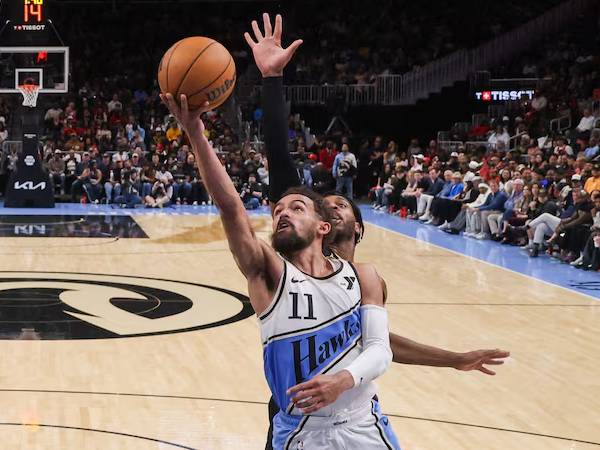 Trae Young (depan) mencetak 25 poin saat Atlanta Hawks mengalahkan tim tamu Golden State Warriors 124-115 pada hari Sabtu (22/3) malam. (Foto: AP)