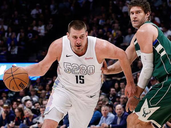 Nikola Jokic (kiri) mencatatkan triple double saat tuan rumah Denver Nuggets mengalahkan Milwaukee Bucks 127-117 pada Rabu (26/3) malam. (Foto: AP)