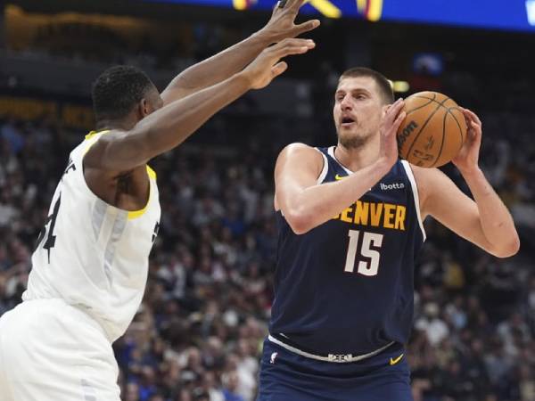 Nikola Jokic (kanan) mencetak 27 poin saat tuan rumah Denver Nuggets membekuk Utah Jazz 129-93 pada Jumat (28/3) malam. (Foto: AP)