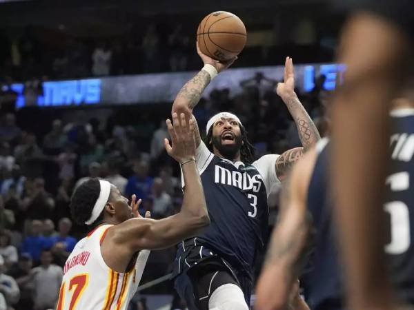 Anthony Davis (kanan) melakukan tembakan floater dengan 3,4 detik tersisa pada hari Rabu (2/4) malam saat Dallas Mavericks menang 120-118 atas tim tamu Atlanta Hawks. (Foto: AP)