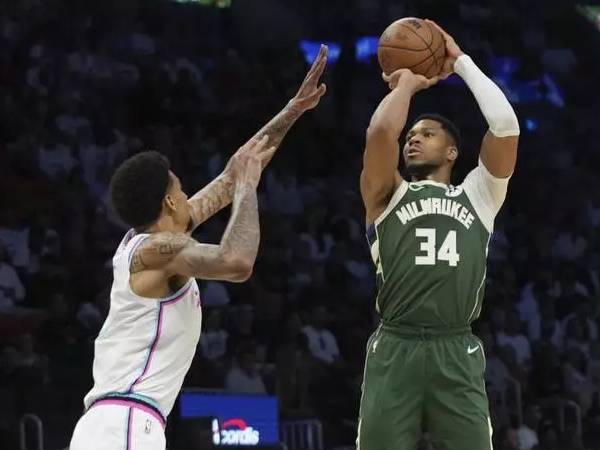 Giannis Antetokounmpo (kanan) mencetak 36 poin saat Milwaukee Bucks mengalahkan tuan rumah Miami Heat 121-115 via overtime pada Sabtu (5/4) malam. (Foto: AP)